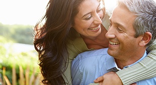 Middle-aged couple hugging and smiling after visiting Delta Dental Premier dentist in Deer Park