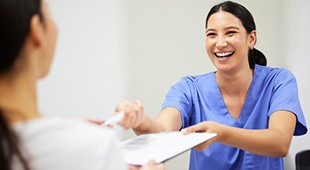 Dental staff member helping patient