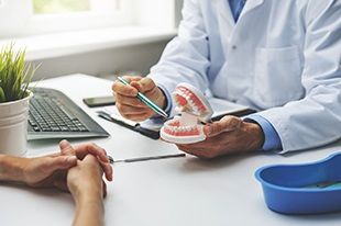  A dentist discussing the possibility of dental implants with a patient during a consultation