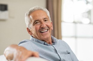 : man smiling while sitting on couch 