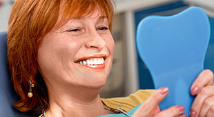 woman smiling into mirror