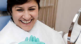 woman holding mirror smiling