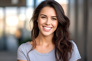 Closeup of woman in grey shirt smiling outside