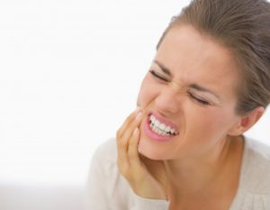 woman holding face in pain