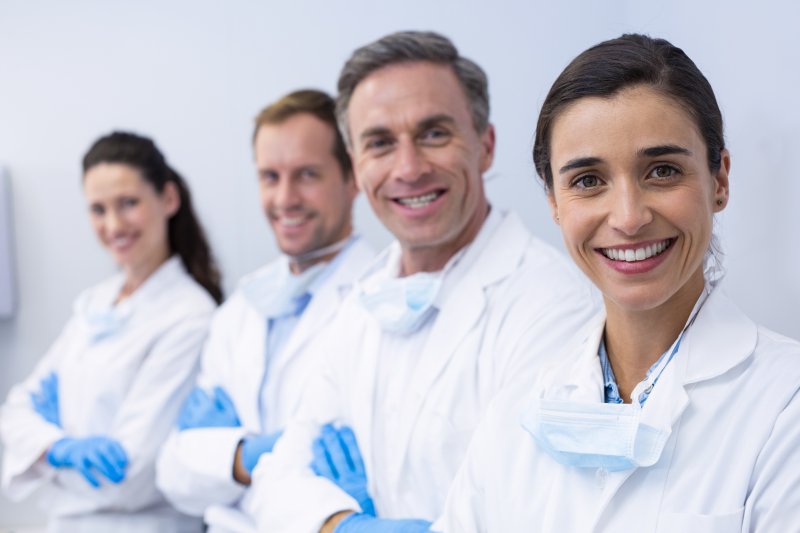 a team of both men and women dental professionals in a line and smiling