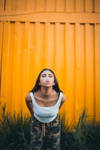 Young woman blowing a bubble with chewing gum