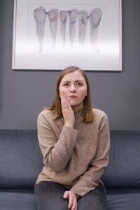 Woman with facial pain waiting at emergency dentist