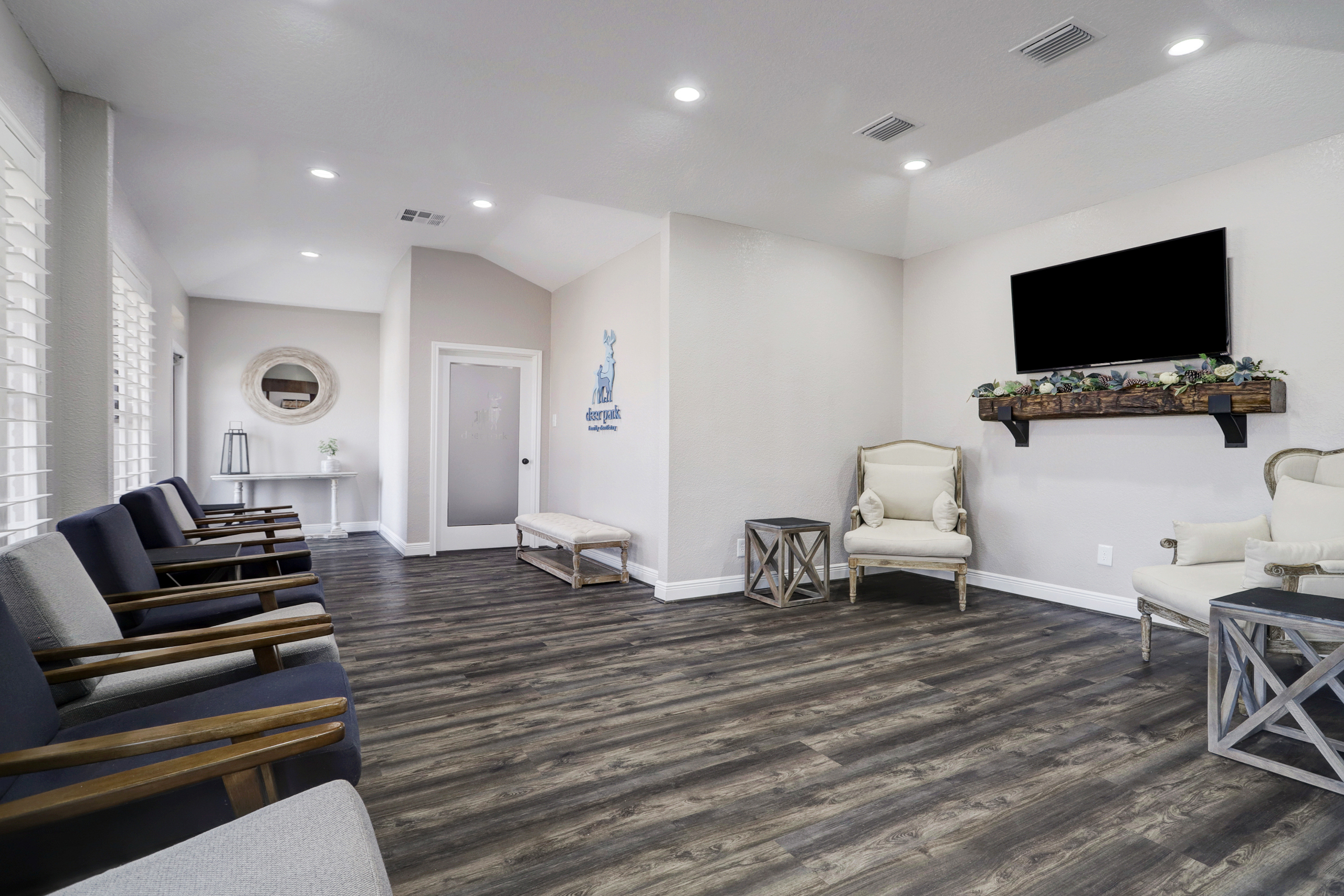 Spacious and modern dental office waiting area – Deer Park Family Dentistry Bright and welcoming waiting area at Deer Park Family Dentistry featuring comfortable chairs, hardwood floors, a mounted TV, and decorative accents creating a relaxing atmosphere – Deer Park Family Dentistry